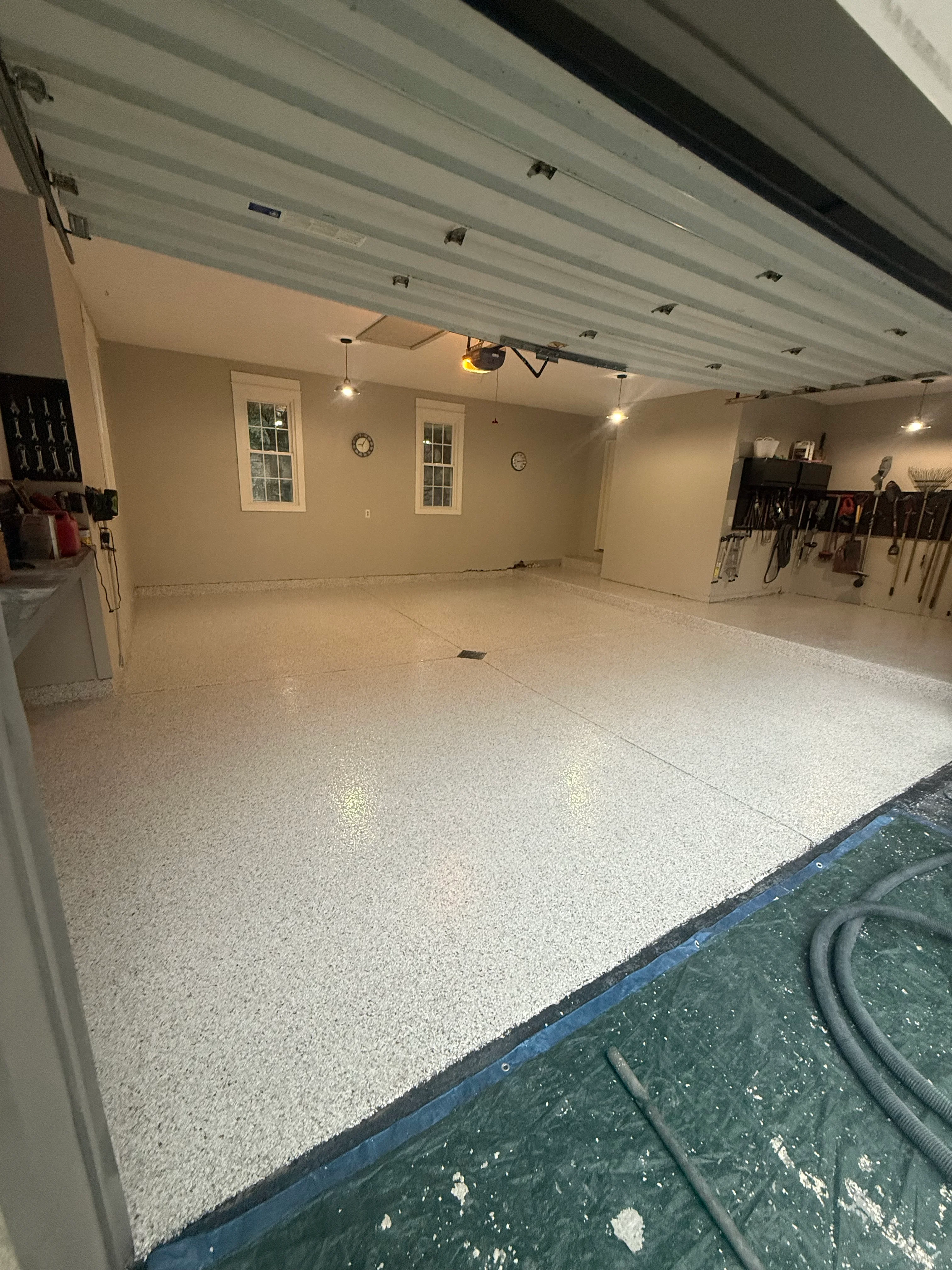 Finished residential garage with light gray speckled epoxy floor coating and LED ceiling lights